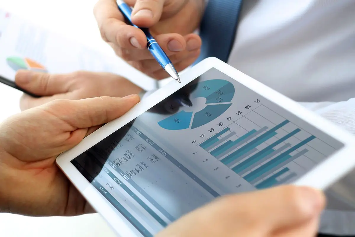 Personnes analysant des graphiques financiers sur une tablette, BDESE