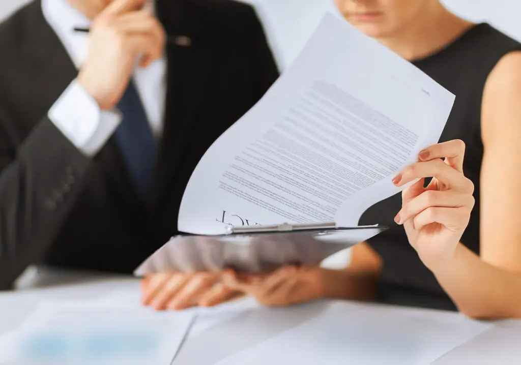 Deux personnes examinant un contrat sur un presse-papiers