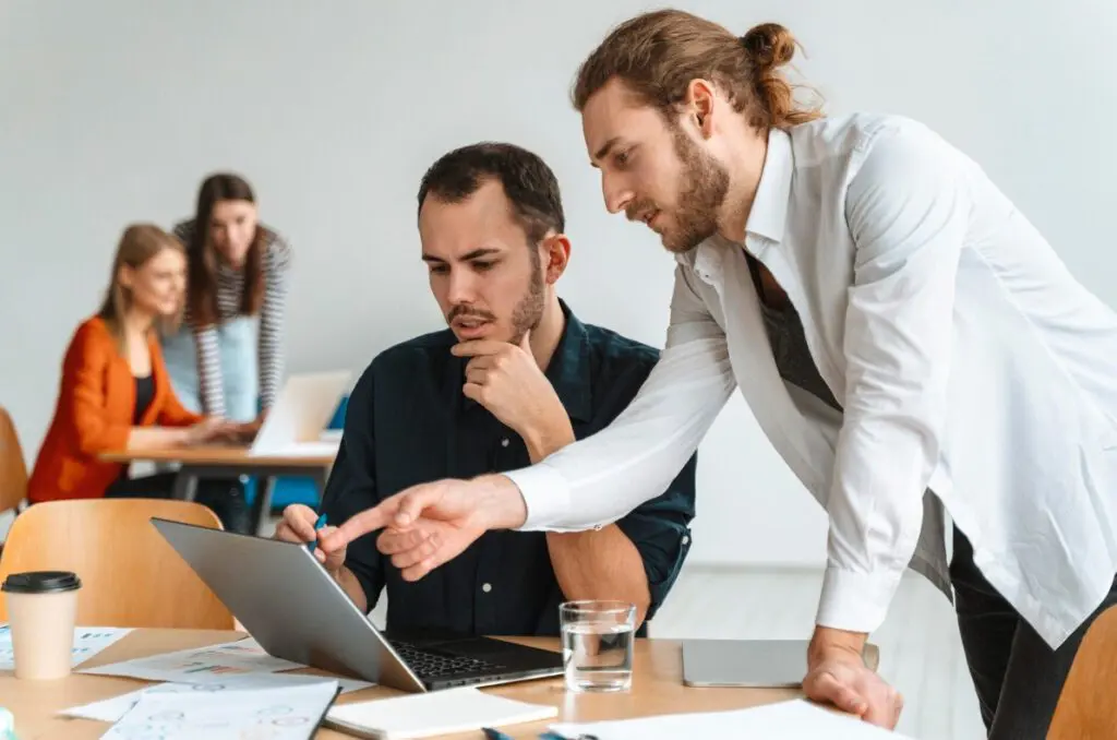 Équipe discutant d'un projet sur un ordinateur portable, formation CSE